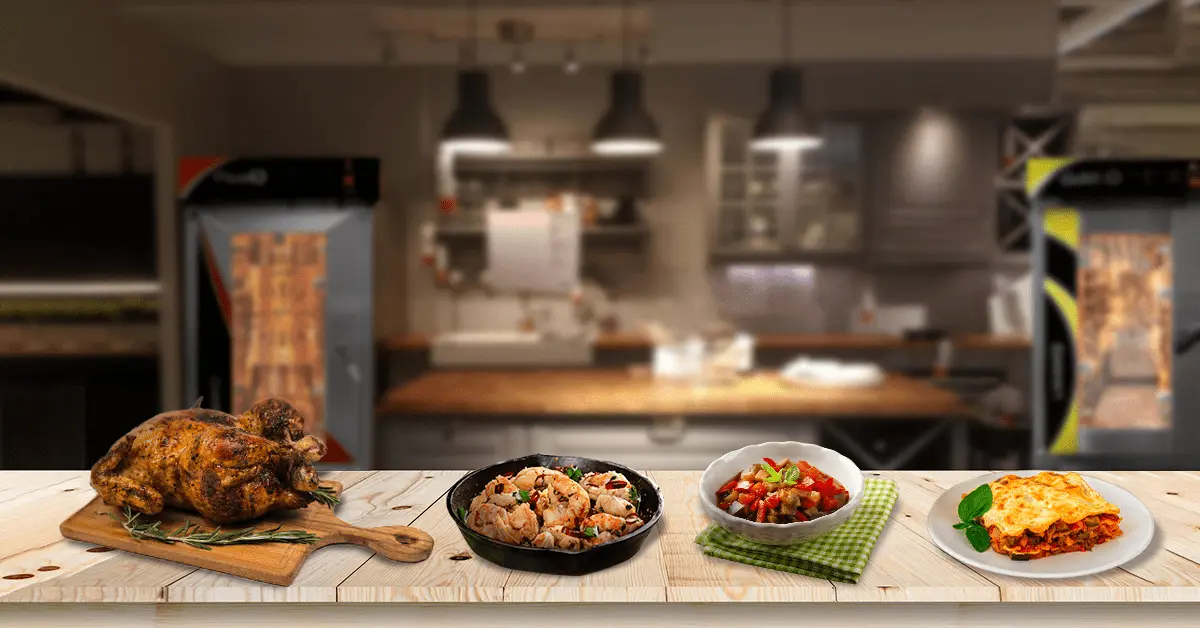 Conjunto de platos principales con hornos de convección colocados sobre una mesa de cocina con hornos de convección LINHER al fondo