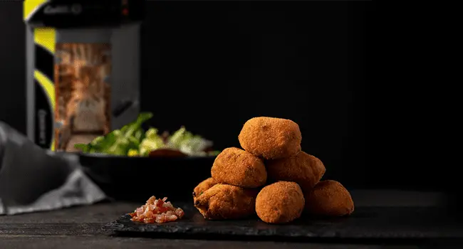 Croquetas de jamón, un aperitivo con hornos de convección mostrado en primer plano con un horno de convección LINHER Goliat al fondo