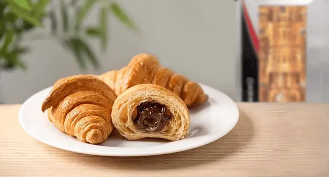 Mini croissants de chocolate, un aperitivo con hornos de convección colocadas en un plato de porcelana con un horno LINHER Plus al fondo