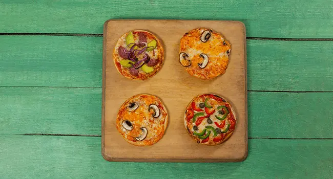 Mini pizzas, un aperitivo con hornos de convección colocadas en una tabla sobre una mesa de madera color verde