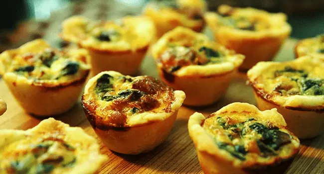 Mini quiches con verduras, un aperitivo con hornos de convección mostrados en conjunto sobre una mesa de cocina