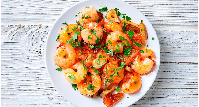 Camarones al ajillo cocinado con hornos de convección servidos en un plato