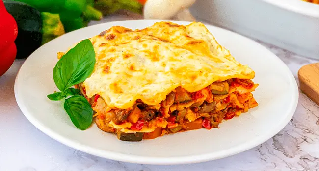 Lasaña de verduras emplatada en una cocina