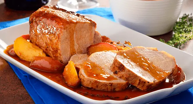 Lomo de cerdo en salsa de manzana sobre una servilleta de color azul