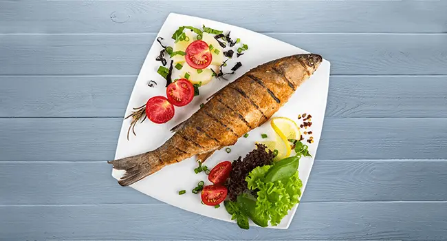 Lubina a la parrilla con verduras uno de los platos principales con hornos de convección con verduras alrededor