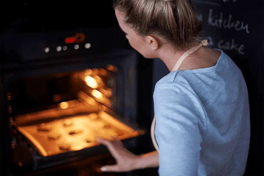 Mujer realizando un monitoreo constante de galletas en los hornos de convección