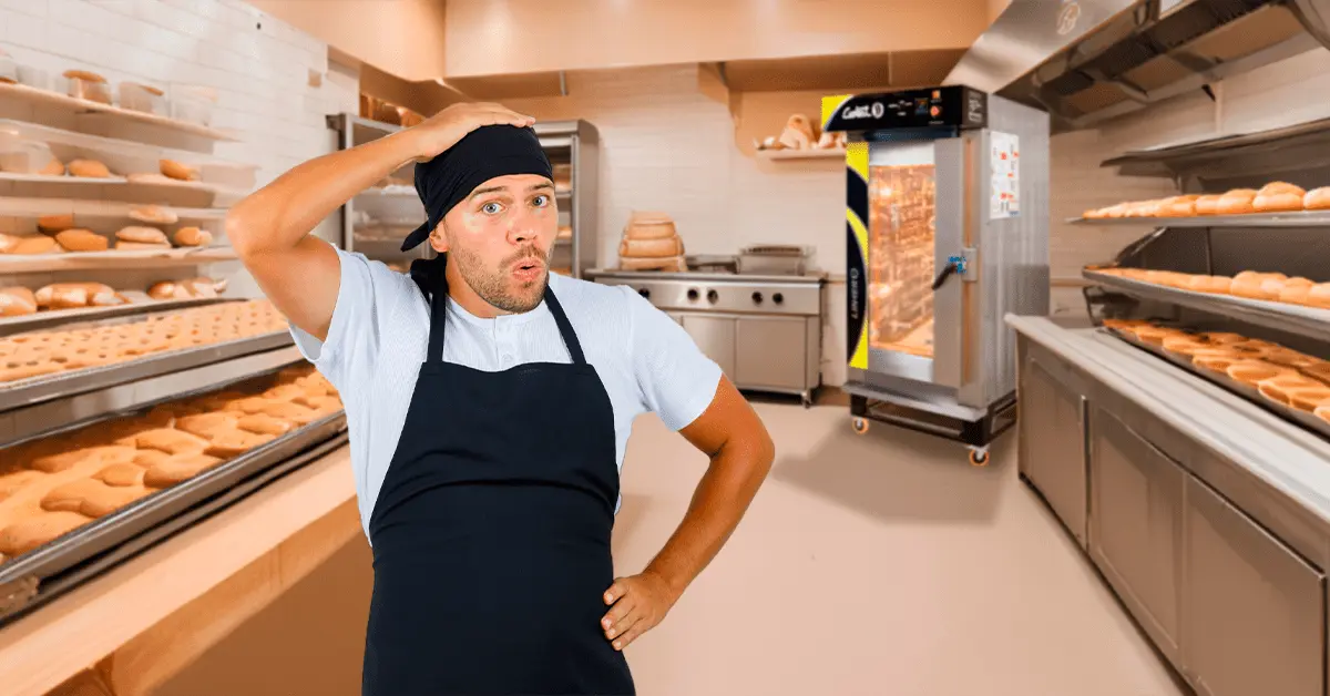 Panadero sorprendido en una cocina de panadería con un horno de convección al fondo