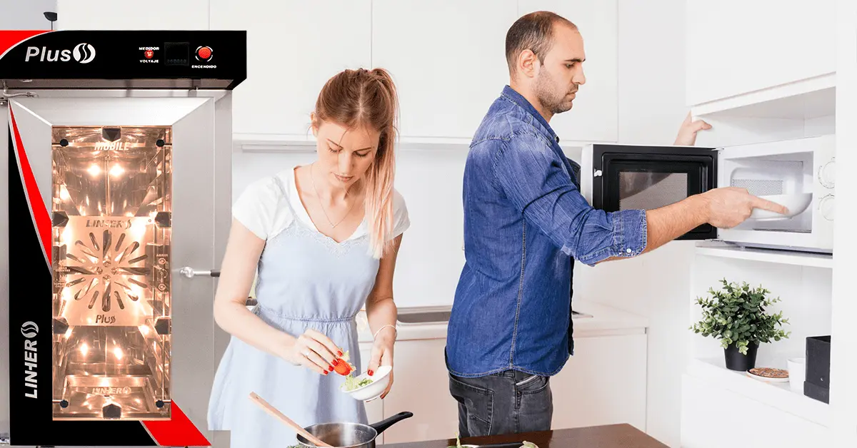 Pareja preparando comida en una cocina moderna mostrando como los hornos de convección pueden mejorar la eficiencia en tu cocina