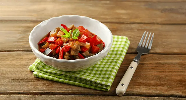 Ratatouille servido en un plato sobre una mesa de madera