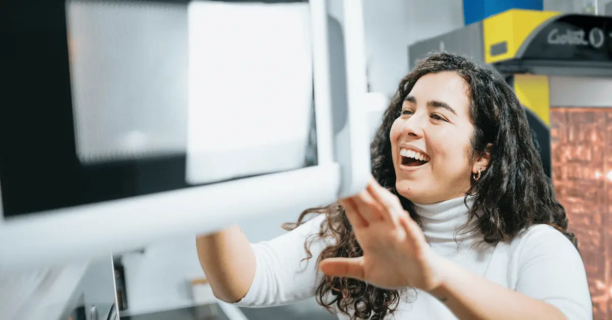 Mujer cocinando en un horno de microondas con un horno de convección LINHER al fondo