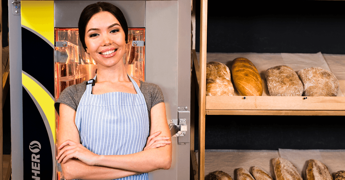 Mujer panadera delante de su horno de convección Goliat en una panadería