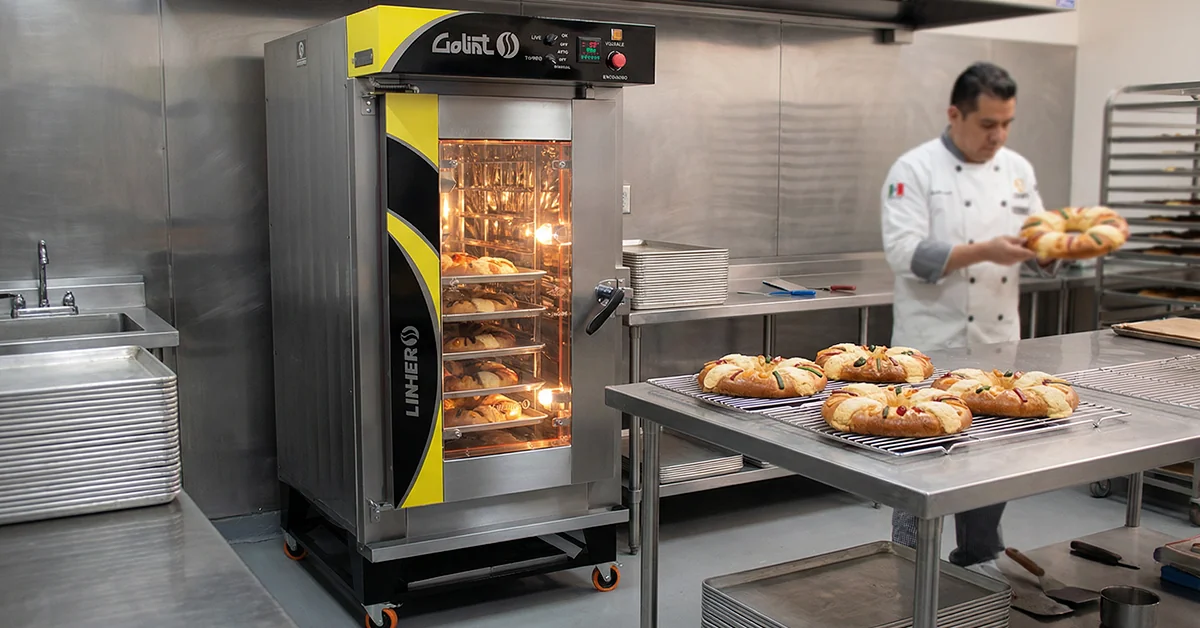 Horno de convección industrial LINHER Goliat horneando Roscas de Reyes de forma uniforme en una panadería profesional ordenada, con producción controlada y enfoque en calidad post-temporada.